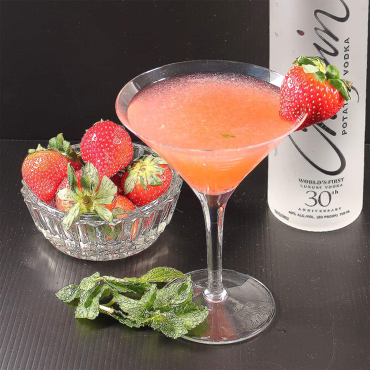 Strawberry Mint Martini in martini glass with strawberry garnish.