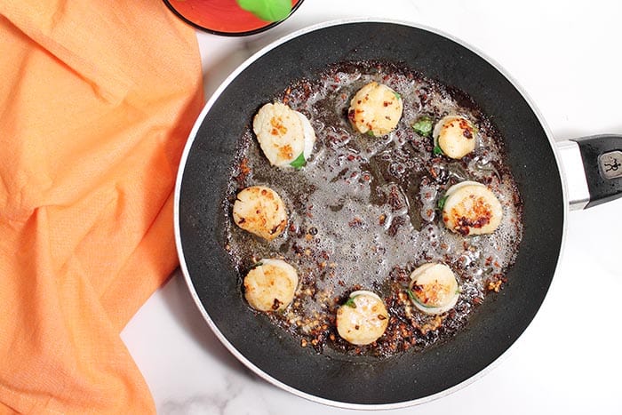 overhead of searing scallops in skillet.