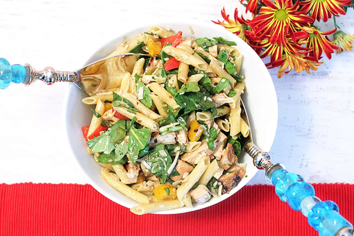 Pasta Saladin white bowl beside red placemat.
