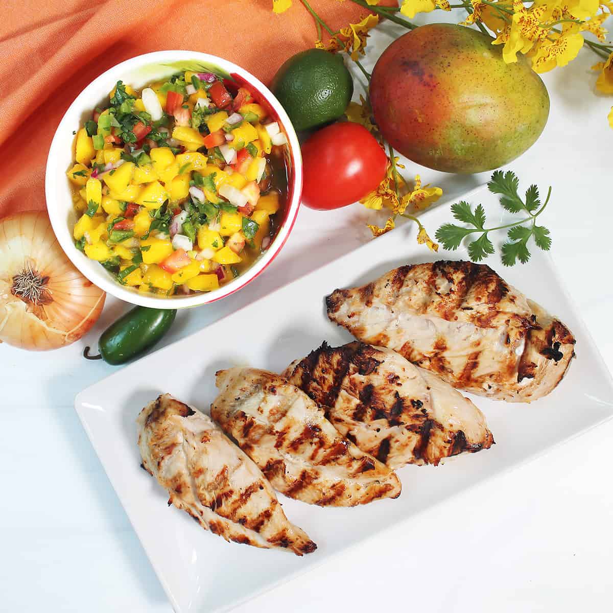 Mango Salsa beside grilled chicken.