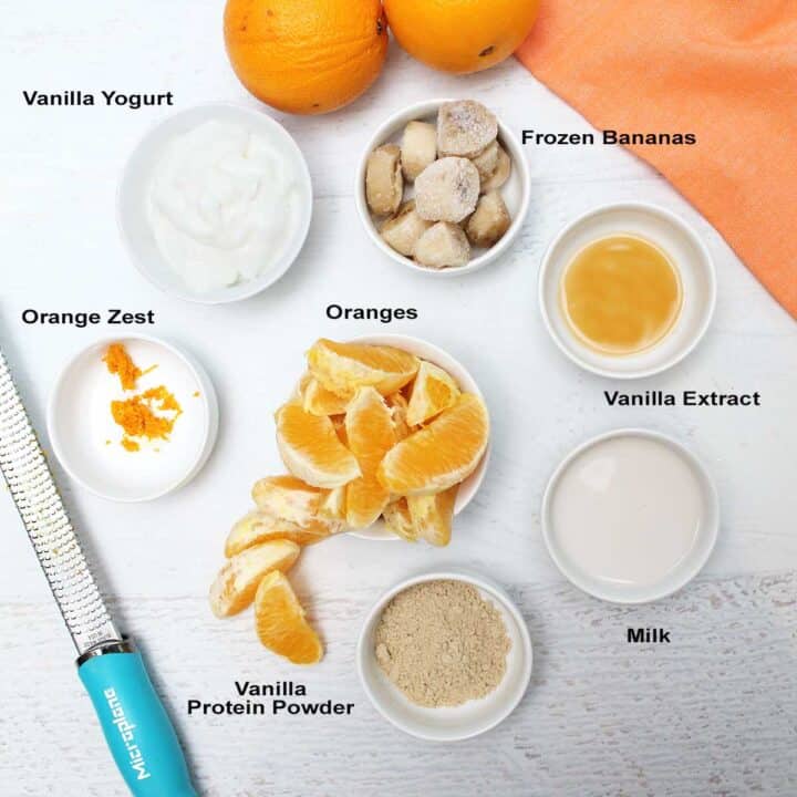 Ingredients on white table with zester and oranges.
