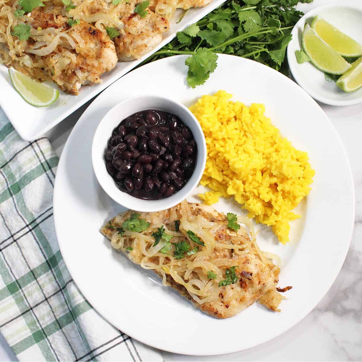 Overhead of plated dinner with black beans and rice and platter of chicken.