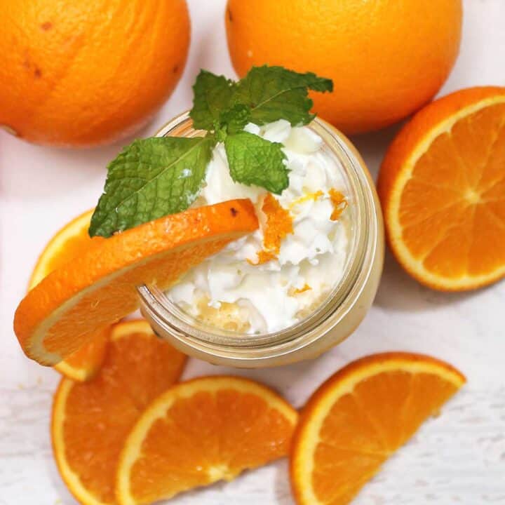 Overhead of smoothie with oranges all around the base.