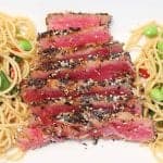 Closeup of sesame tuna dinner on white platter.