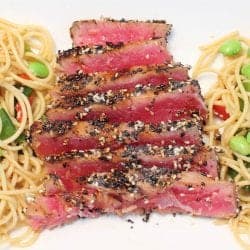 Closeup of sesame tuna dinner on white platter.
