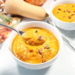 Spoonful of soup over bowl.