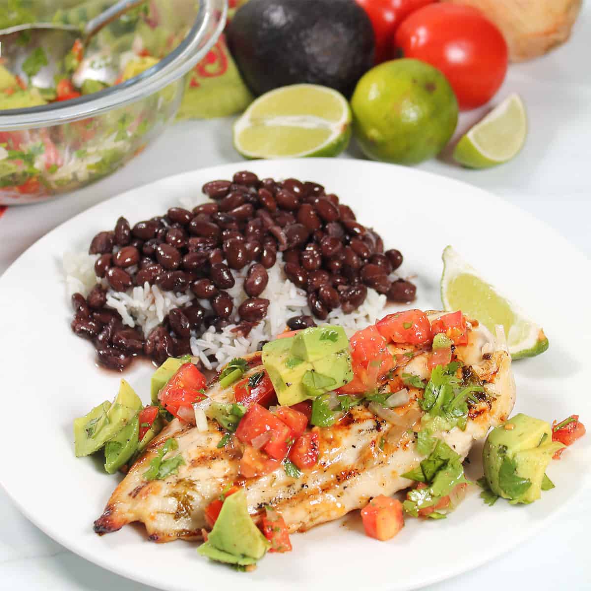 Grilled Chicken with avocado salsa on plate with black beans.