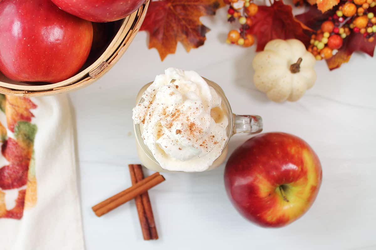 Overhead of apple smoothie with nutmeg topped whipped cream.