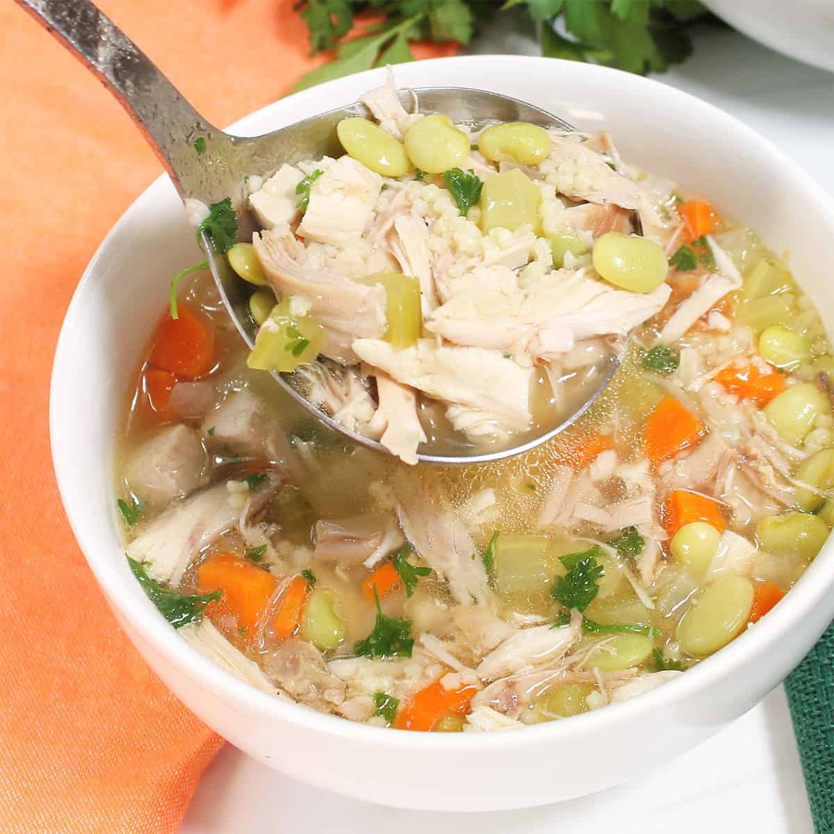 Ladling soup into white bowl.
