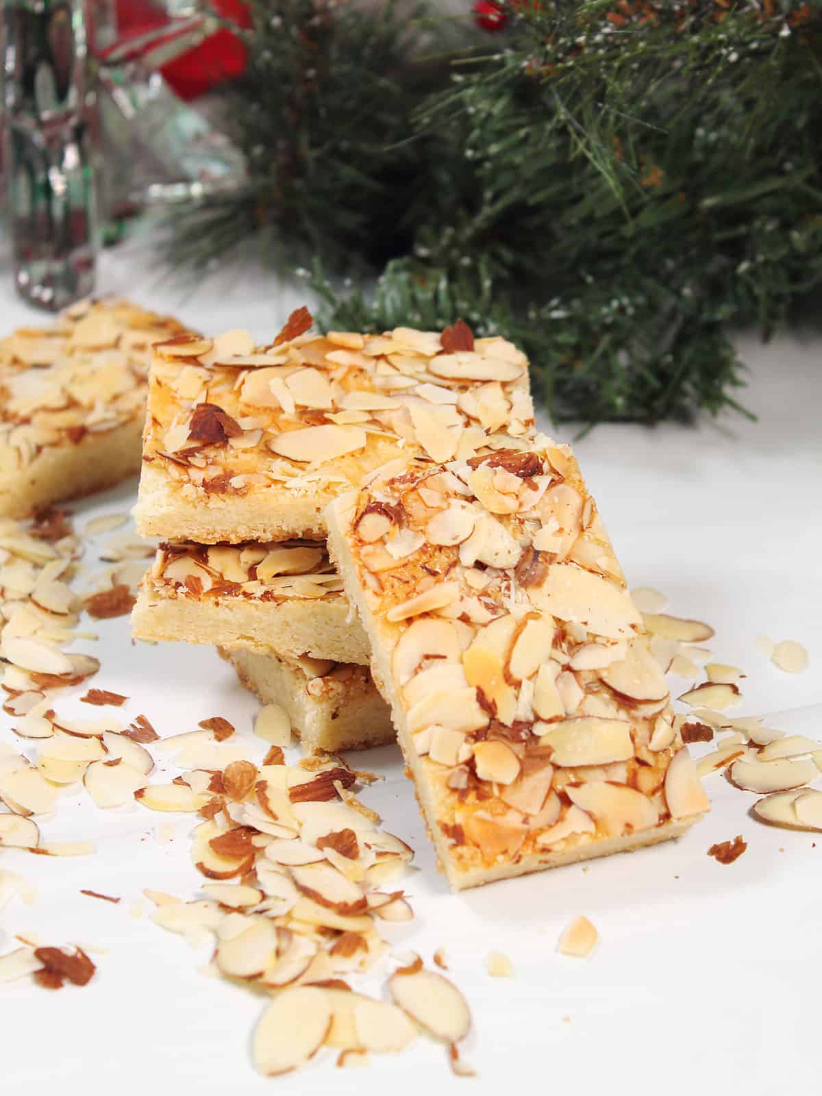 Stacked almond bars near evergreen bough.