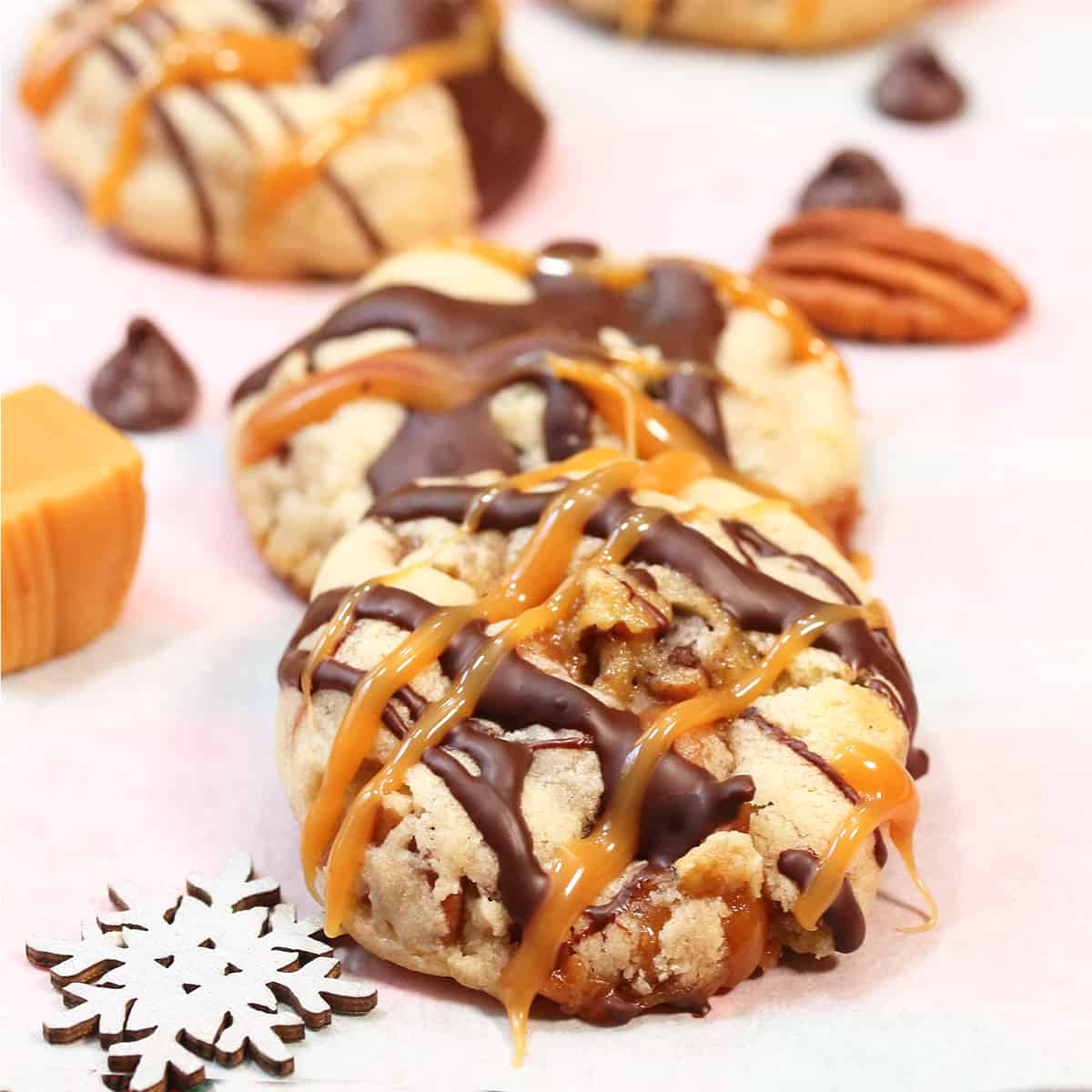 Turtle Cookies on parchment paper with caramels, chocolate chips and a snowflake.