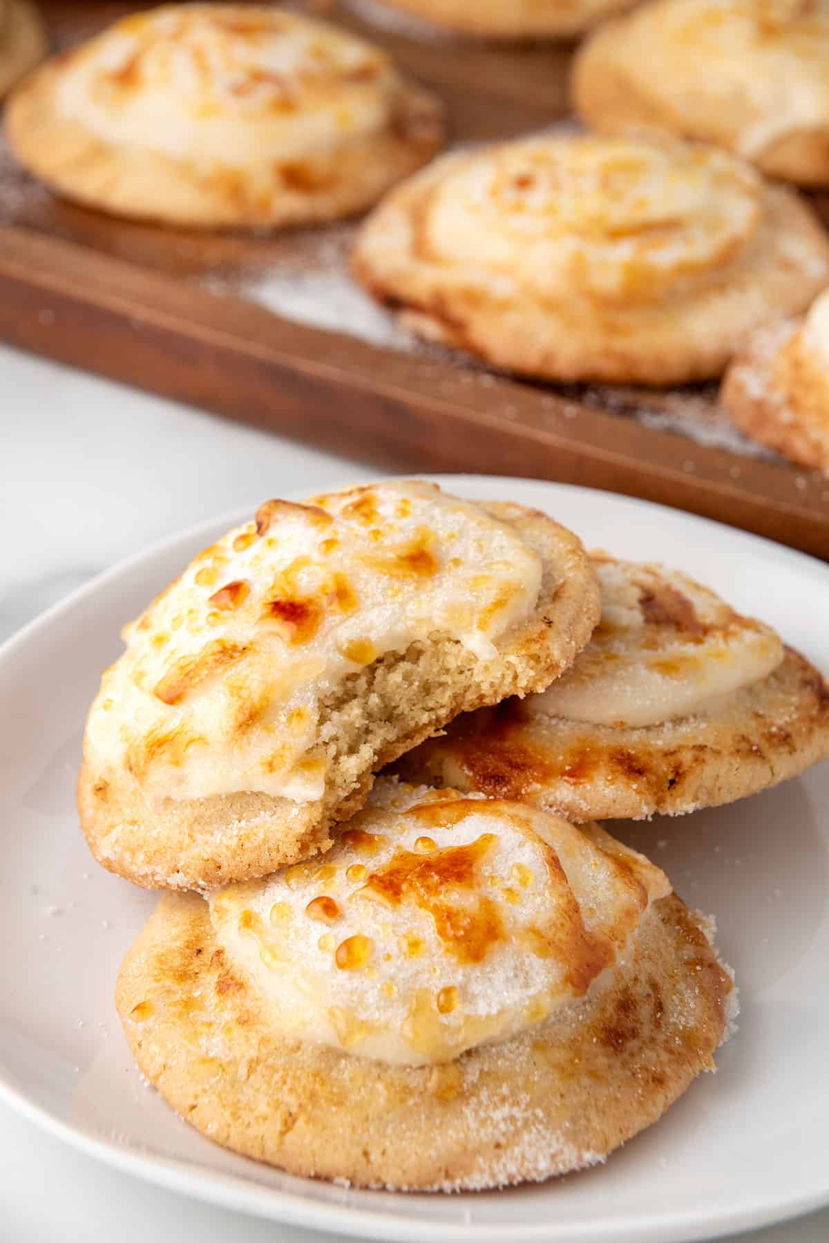 Creme Brulee cookies on a plate with bite out of top one.