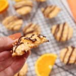 Closeup of cookie with bite out of it over wire rack of cookies.