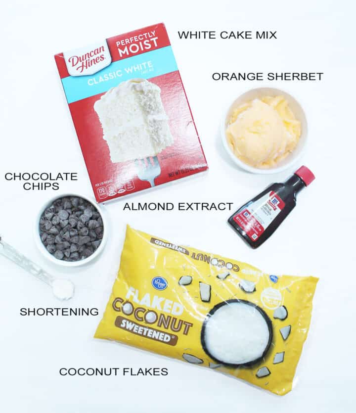 Ingredients for orange macaroons on white table.