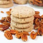 A stack of Pecan Sandies Cookies among pecans.