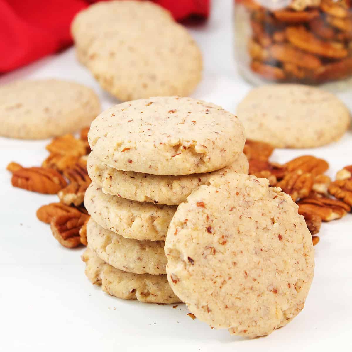 Pecan Sandies by pecans with one leaning on stack.