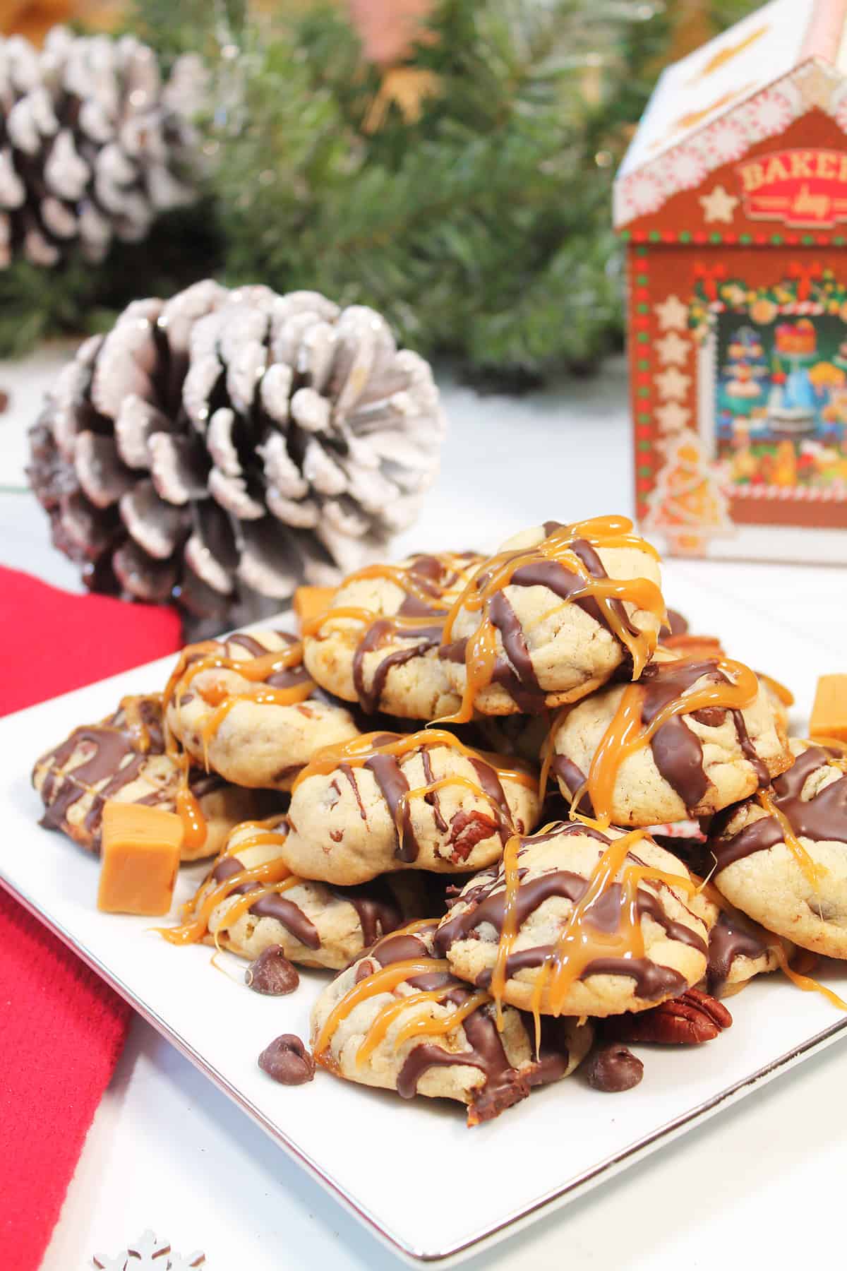 Plateful of turtle cheesecake cookies with pinecone in back.