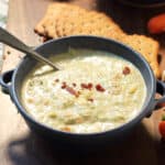 Bowl of bacon garnished soup with spoon in it.
