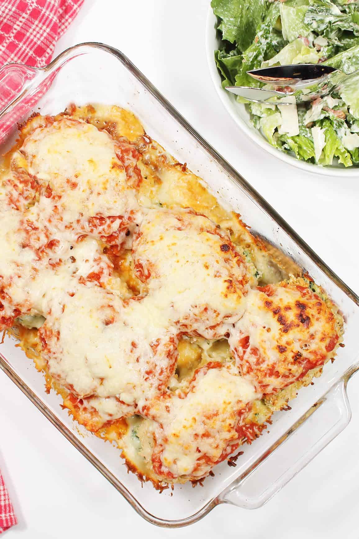 Overhead of baked stuffed chicken with salad.