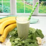 Spinach Banana Smoothie with straw by window,