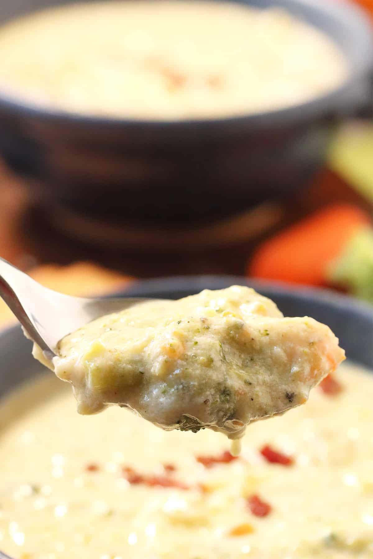 Spoonful of soup over bowl.