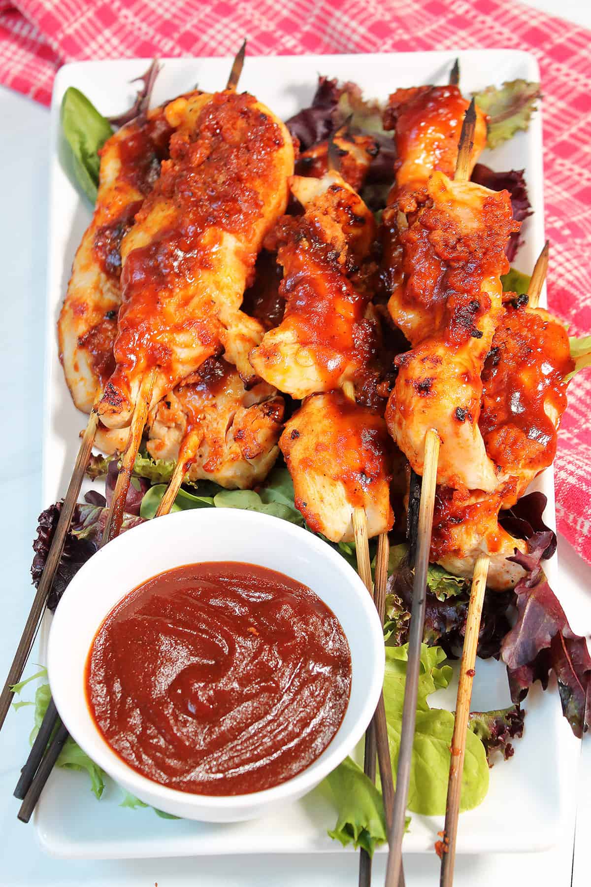 BBQ Chicken Skewers on platter with bowl of bourbon BBQ sauce.