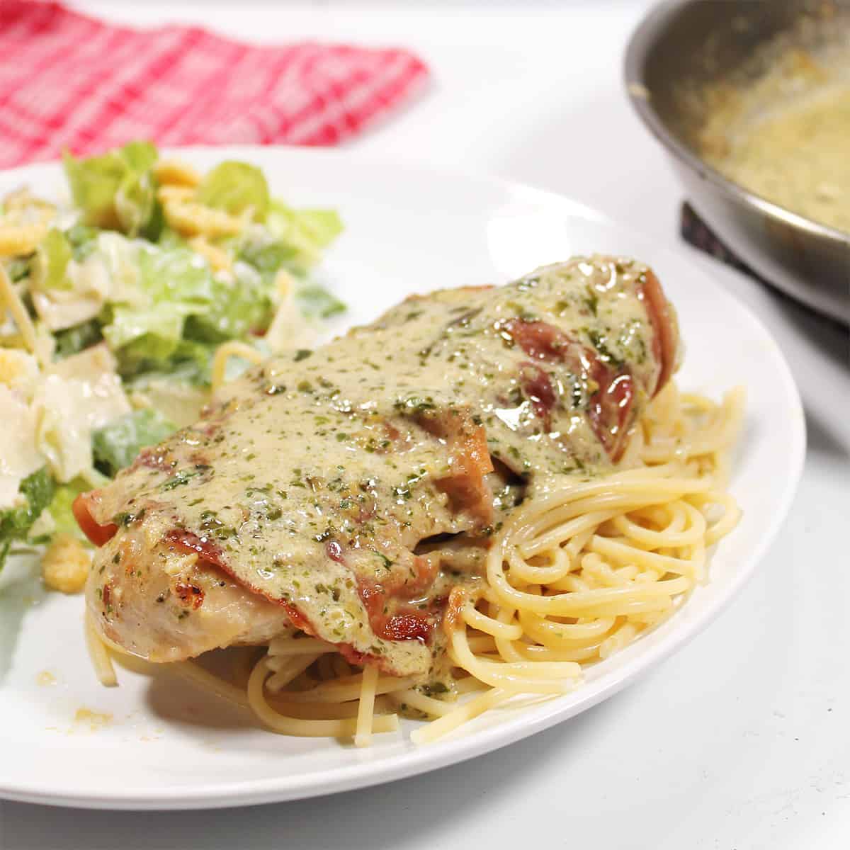 Closeup of chicken breast with basil cream sauce.