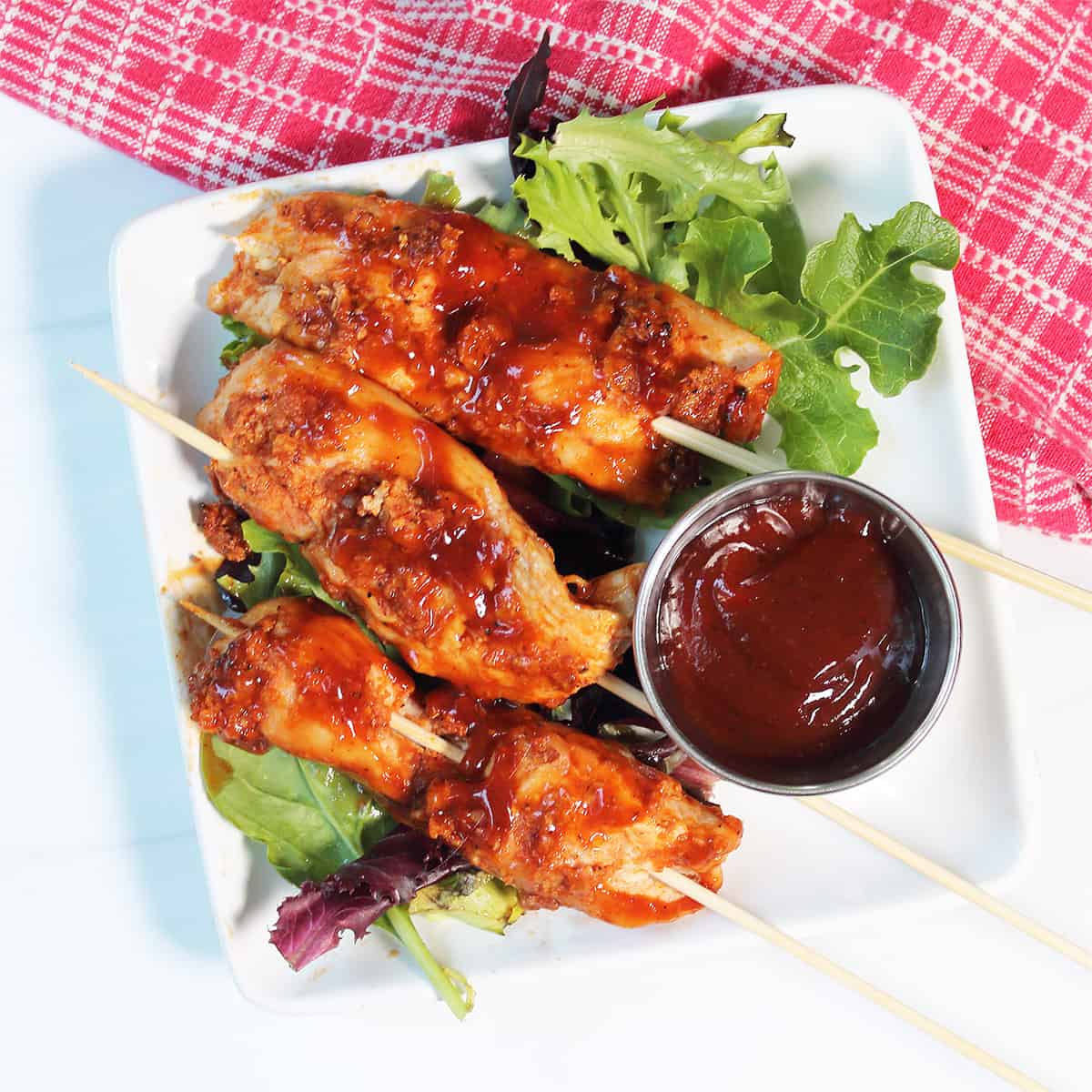 Overhead of plated chicken skewers with bourbon BBQ sauce.