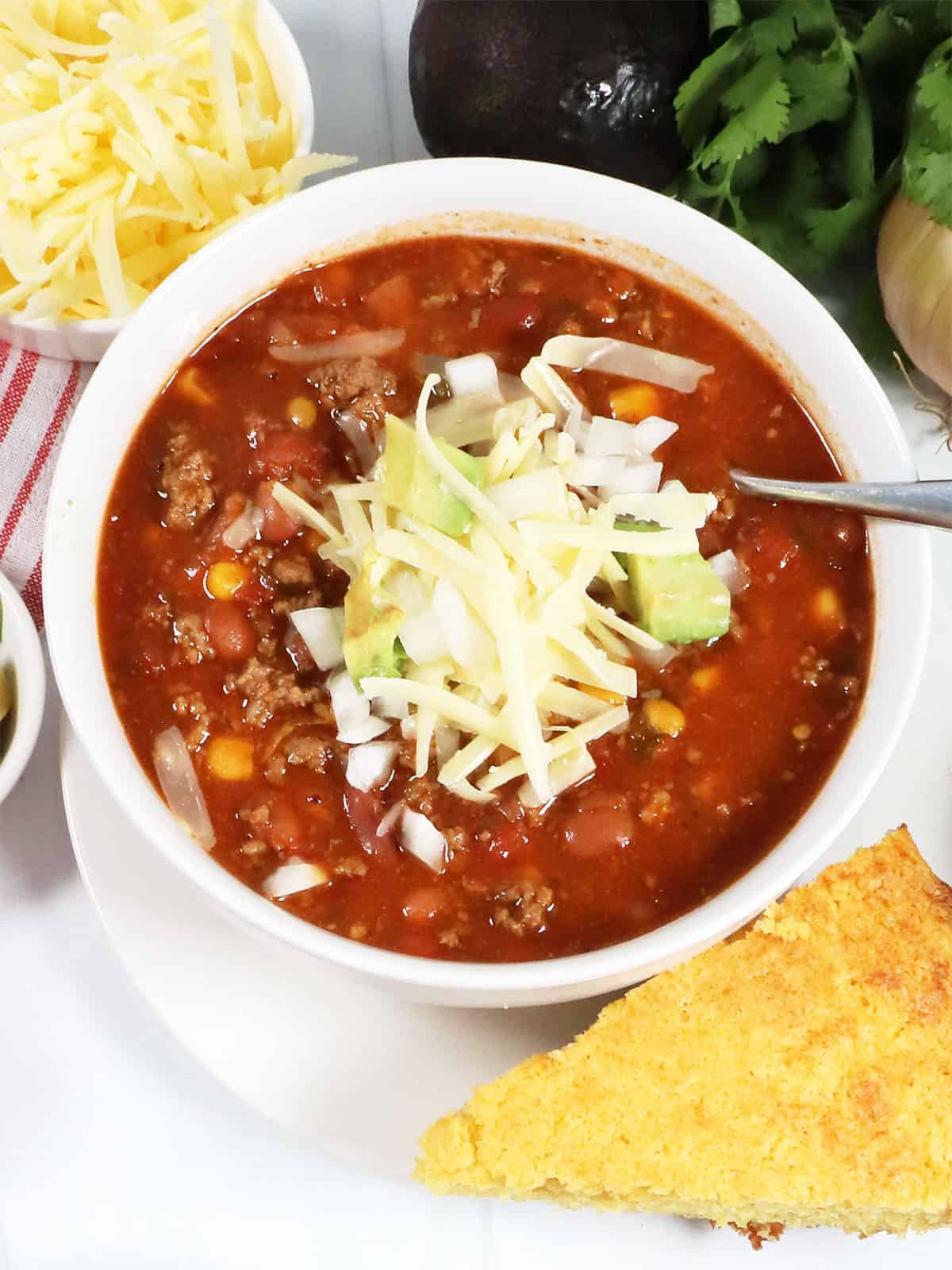 Closeup of crockpot chili with shredded cheese on top