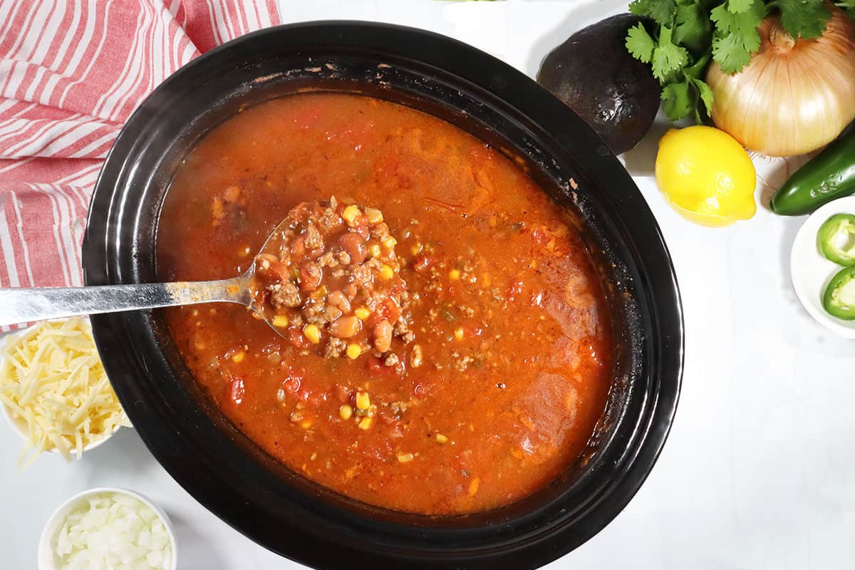Ladleful of easy slow cooker chili above crockpot.