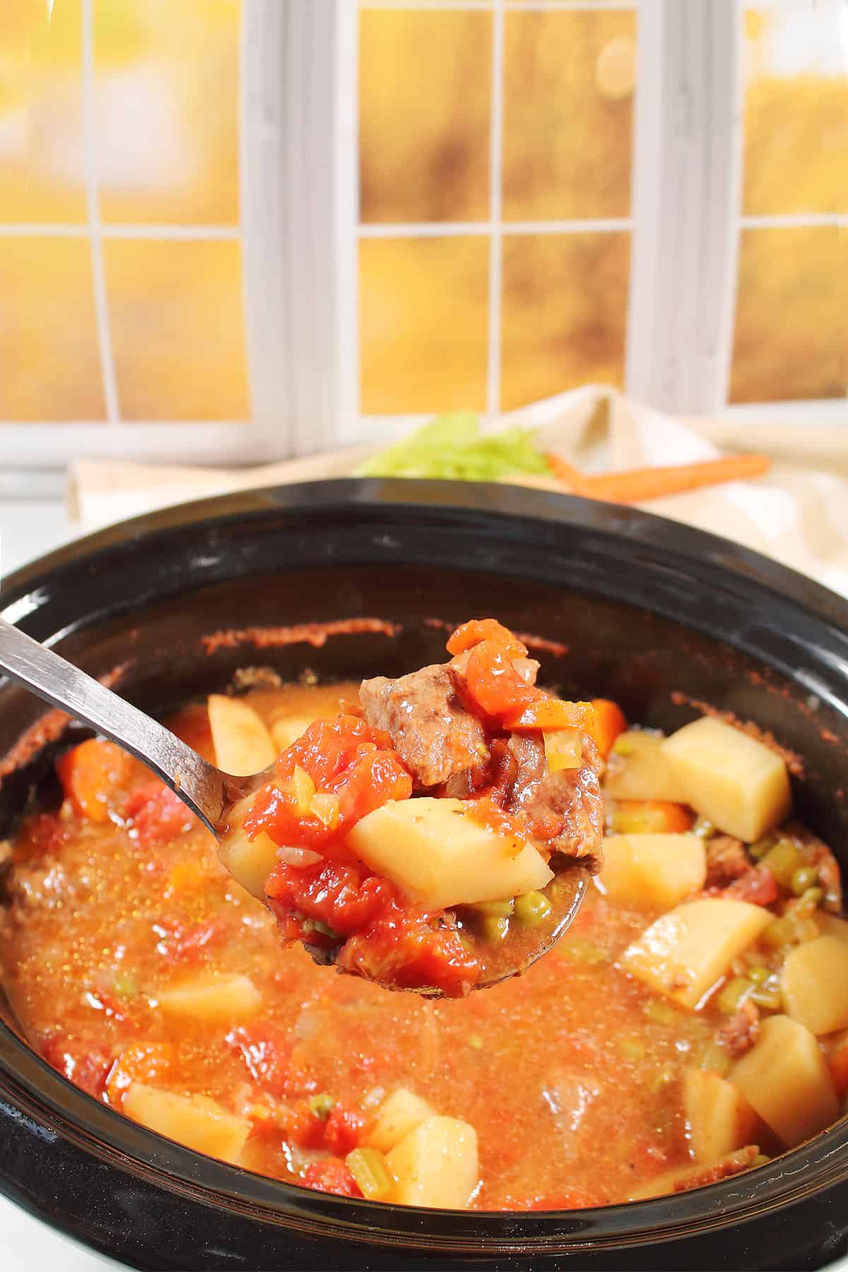 Ladling up slow cooker beef stew from crock pot.