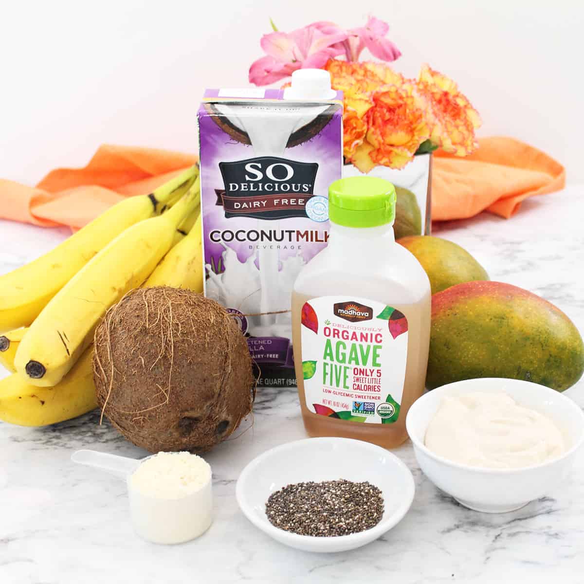 Smoothie ingredients laid on white table.