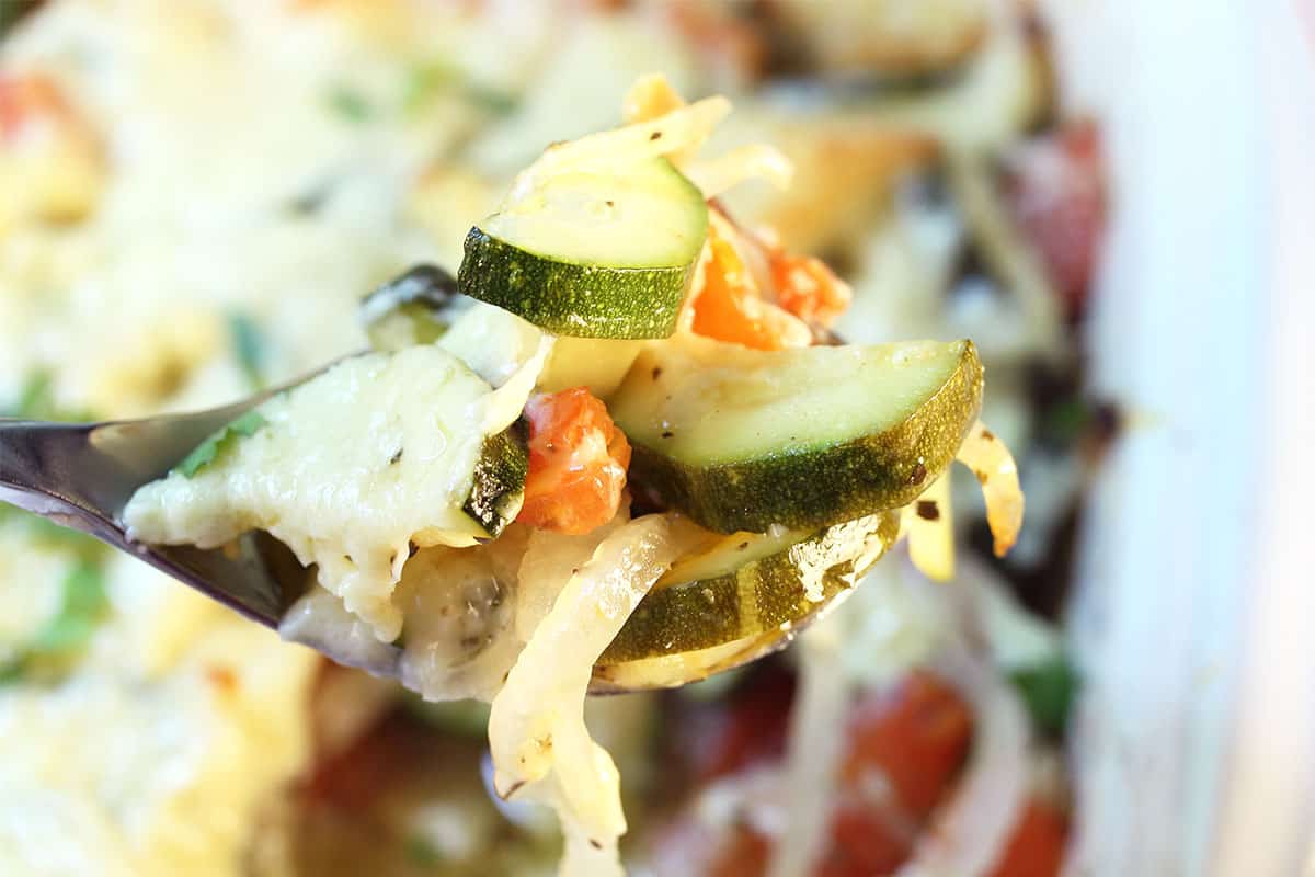 Spoonful of cheesy zucchini and tomatoes.