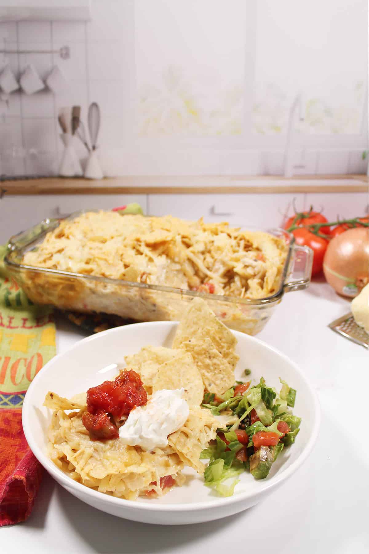 Bowl of serving of southwest chicken bake with full casserole in back.