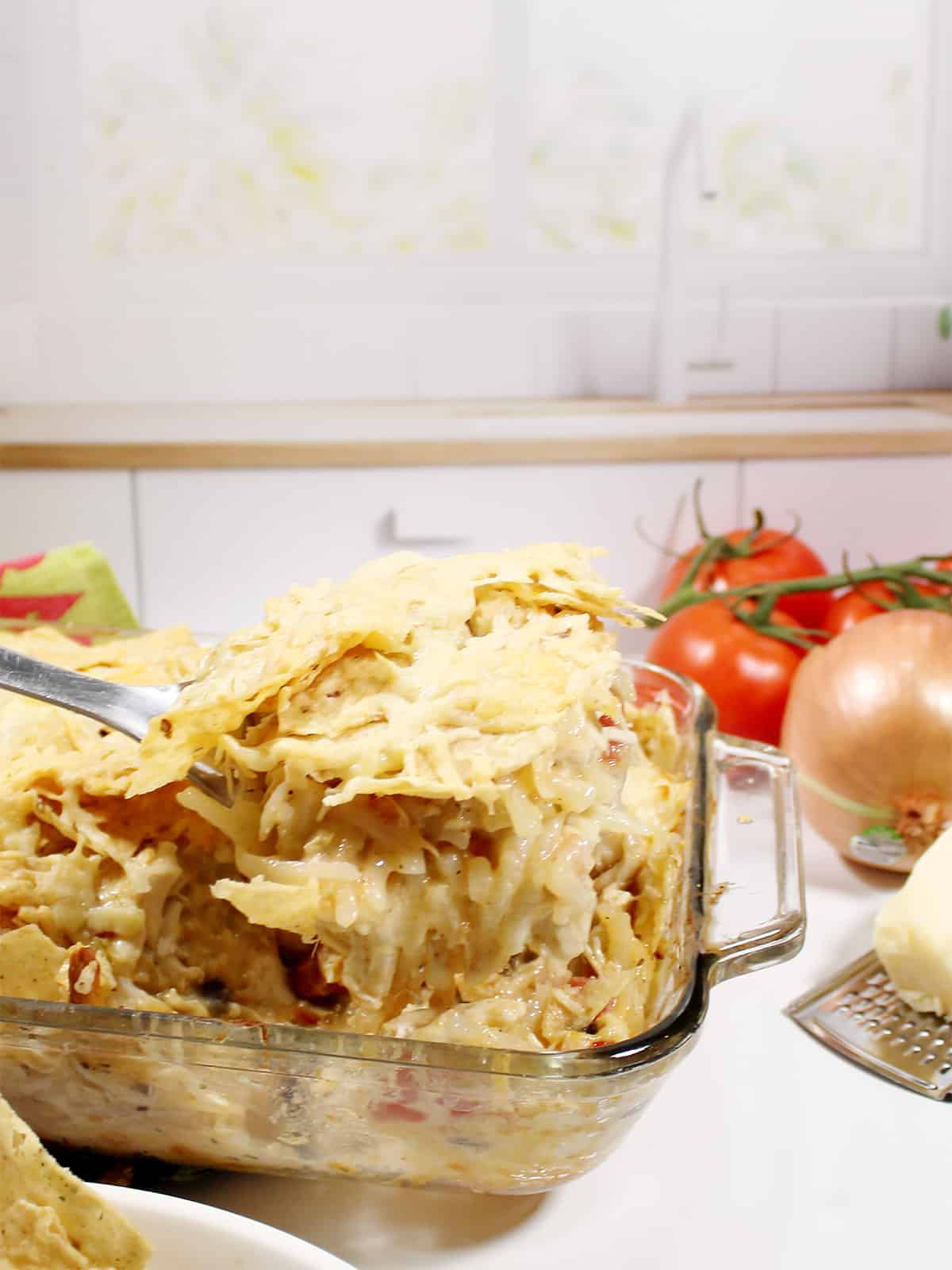 Lifting serving of chicken casserole out of baking dish.