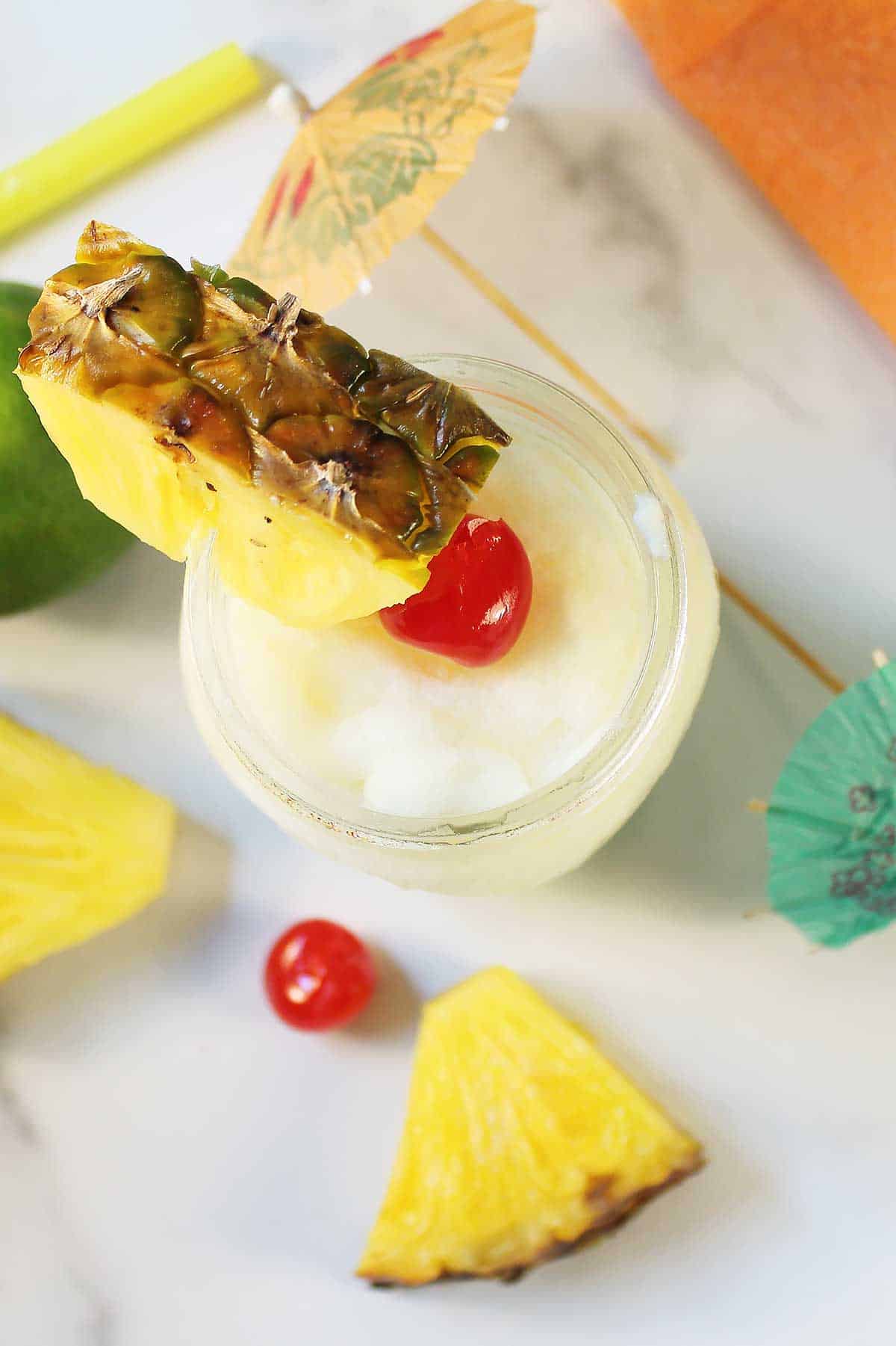 Overhead of frozen cocktail with pineapple garnish.