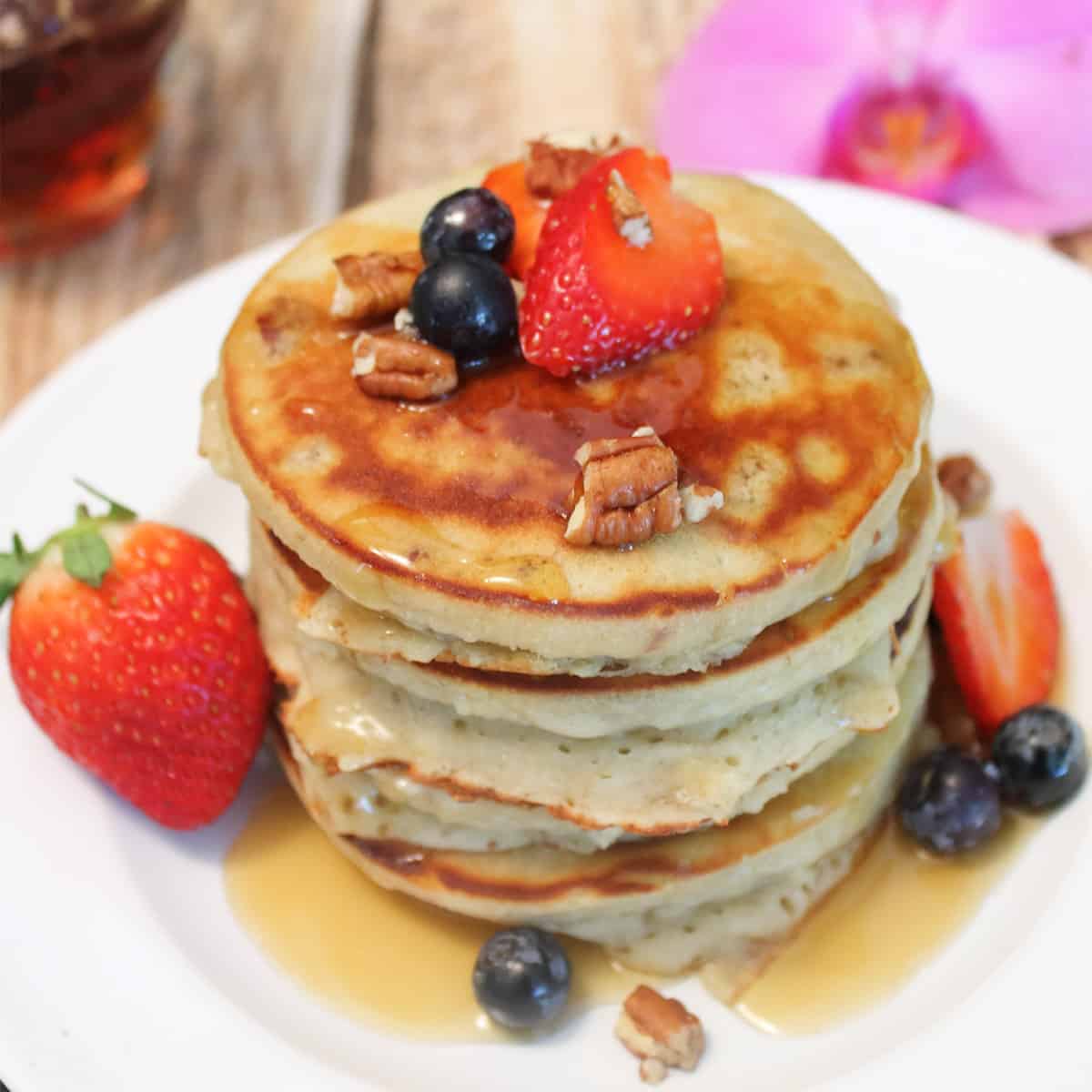Stack of gluten free pancakes with syurp on them.