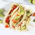 Showing chicken tacos stuffed with fillings.