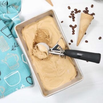 Scooping no churn coffee ice cream out of loaf pan.