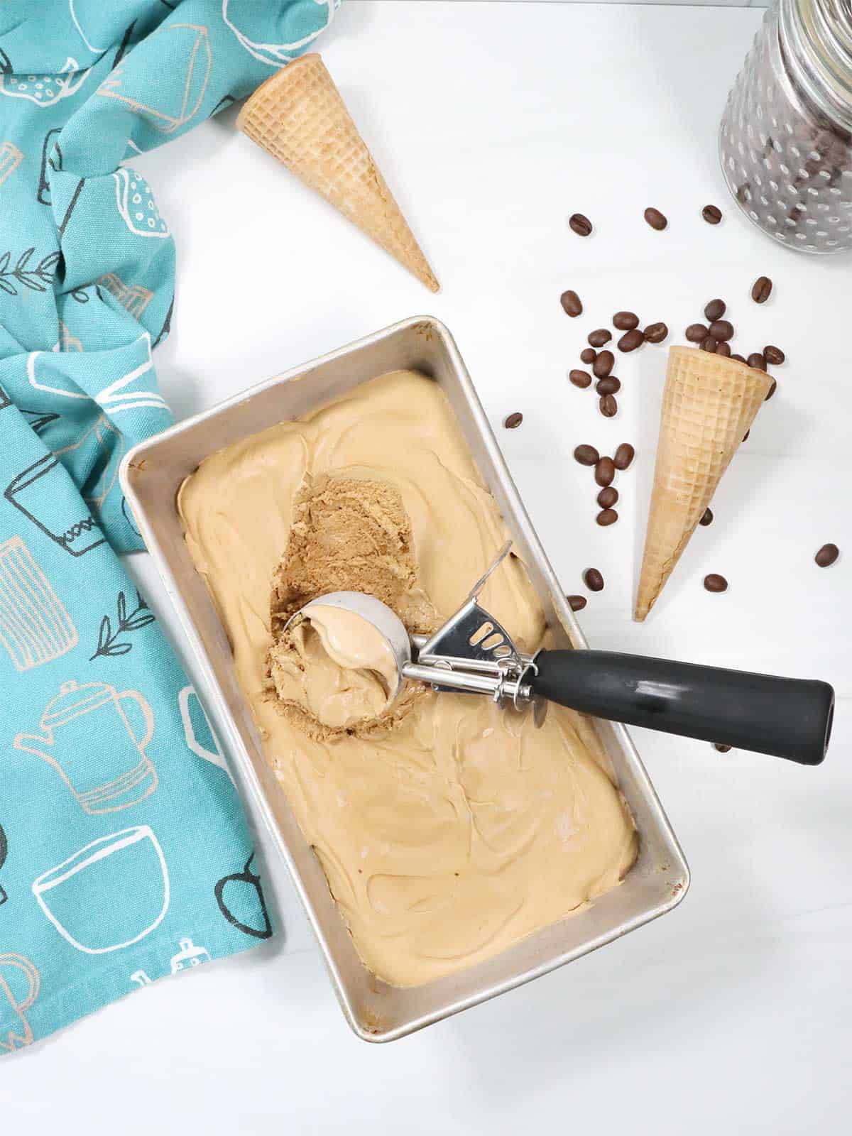 Scooping espresso coffee ice cream out of pan.
