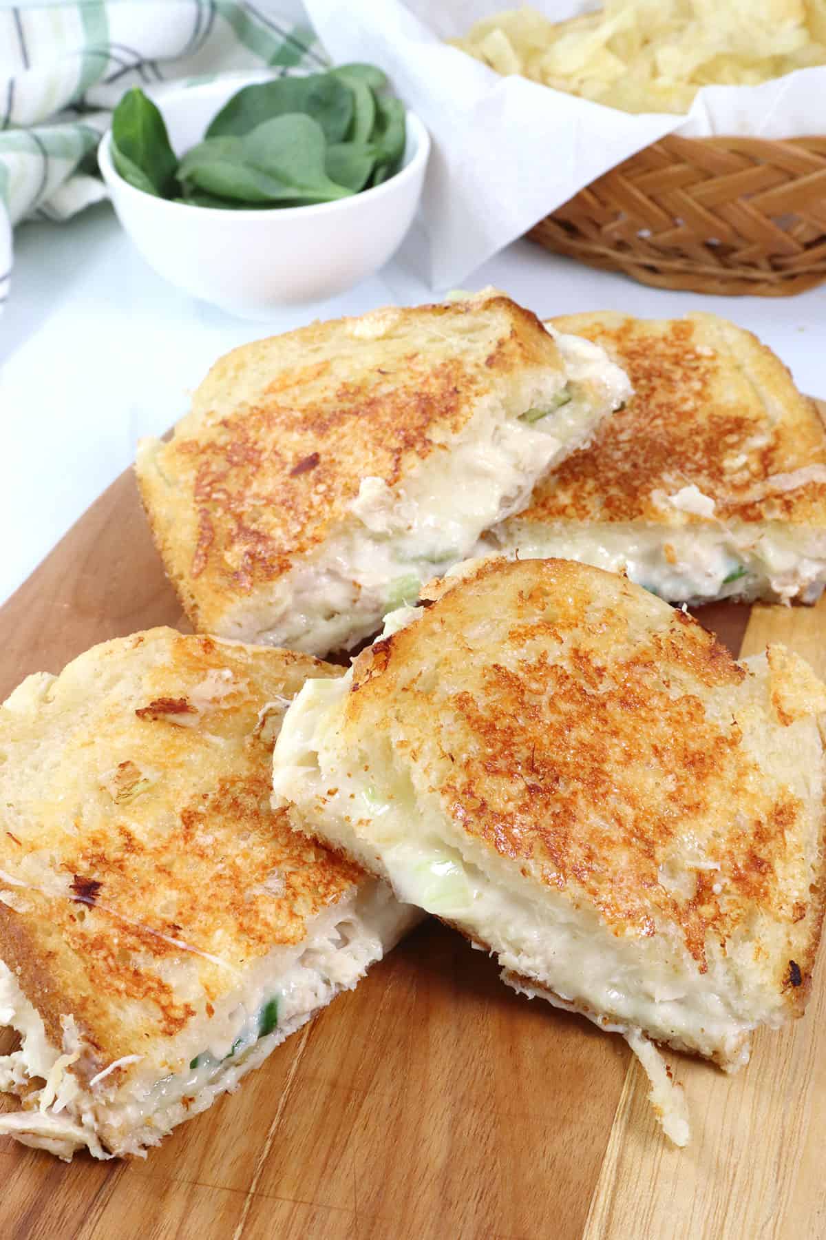 Halved tuna melts on cutting board.
