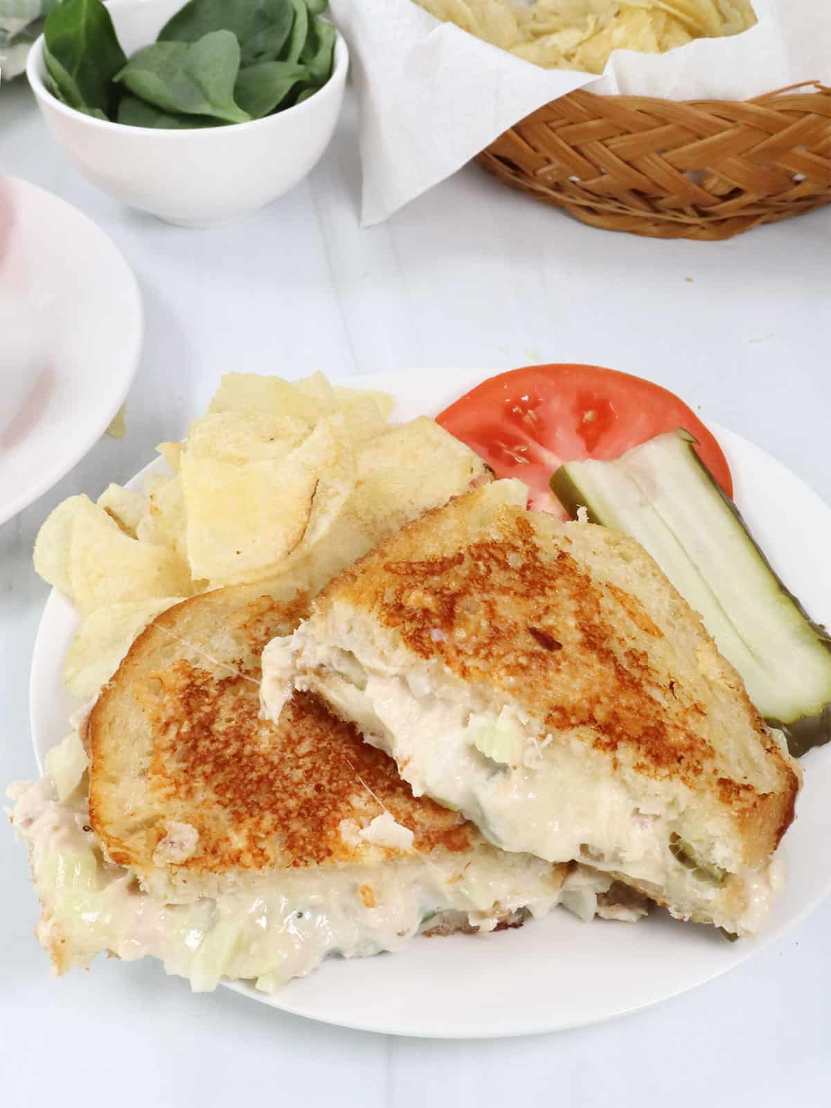 Cheesy Tuna Melt with chips and pickle.