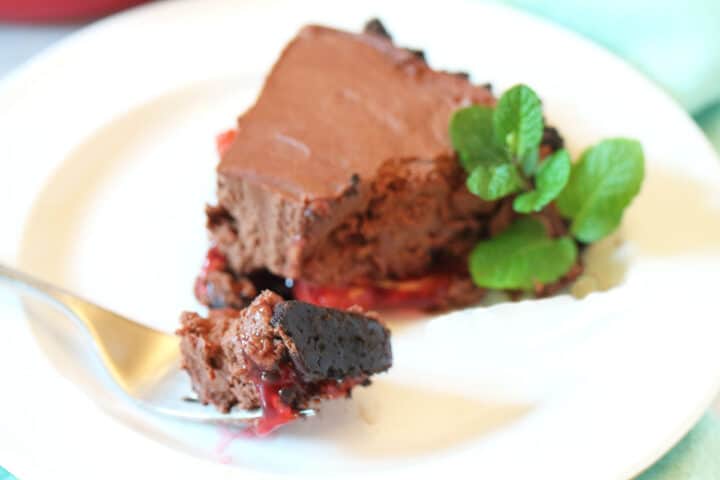 Plated slice of chocolate cherry pie with bite on fork.
