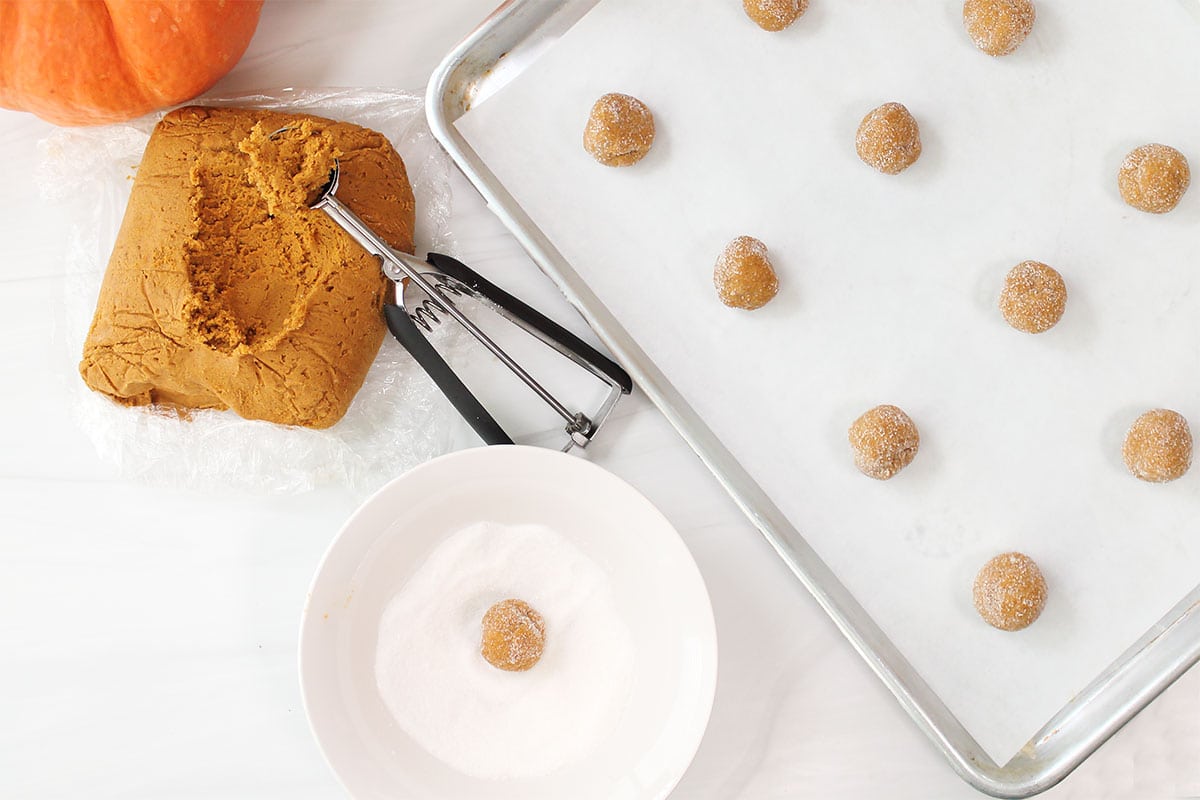Rolling balls of cookie dough in sugar.