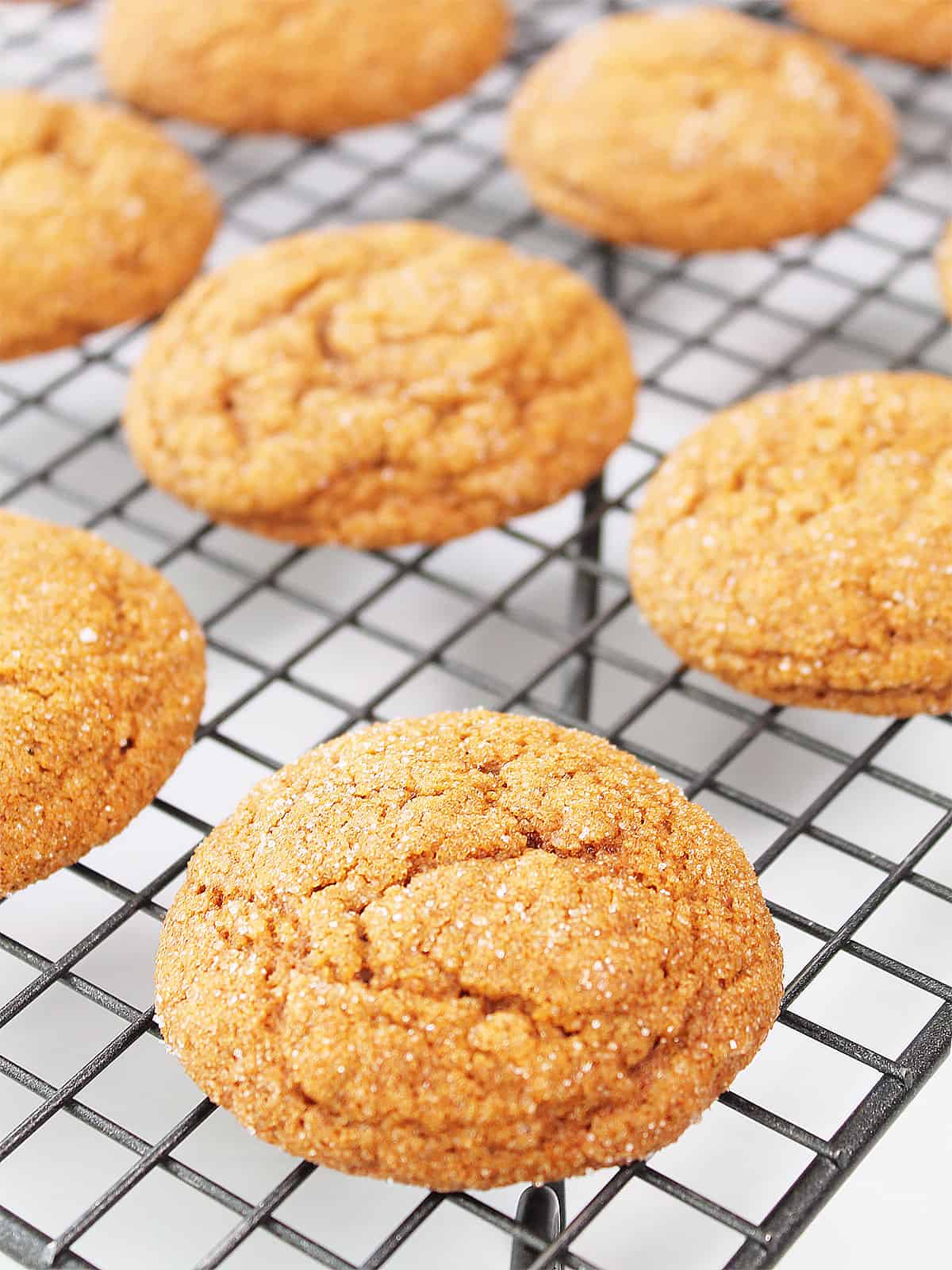 Baked pumpkin spice molasses cookies on wire rack.