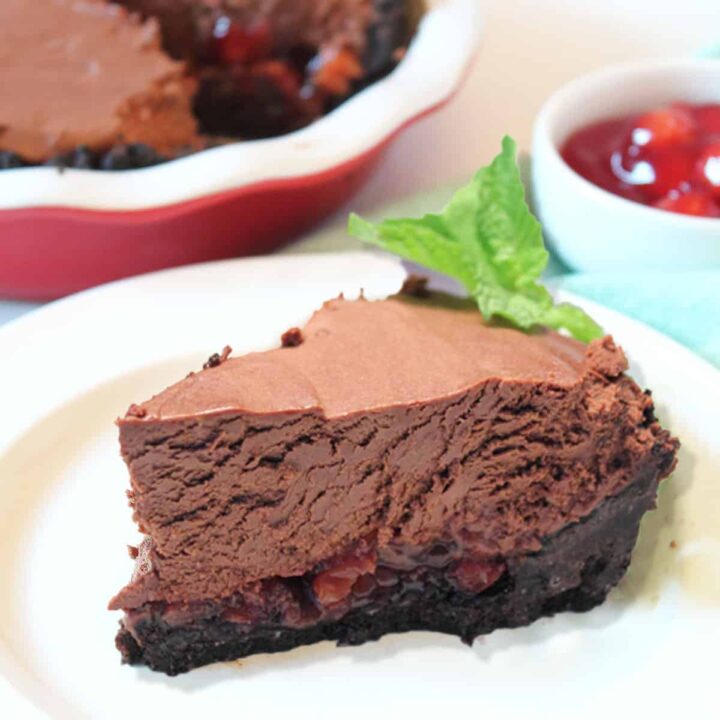 Slice of no bake chocolate tarton white plate with pie in background.