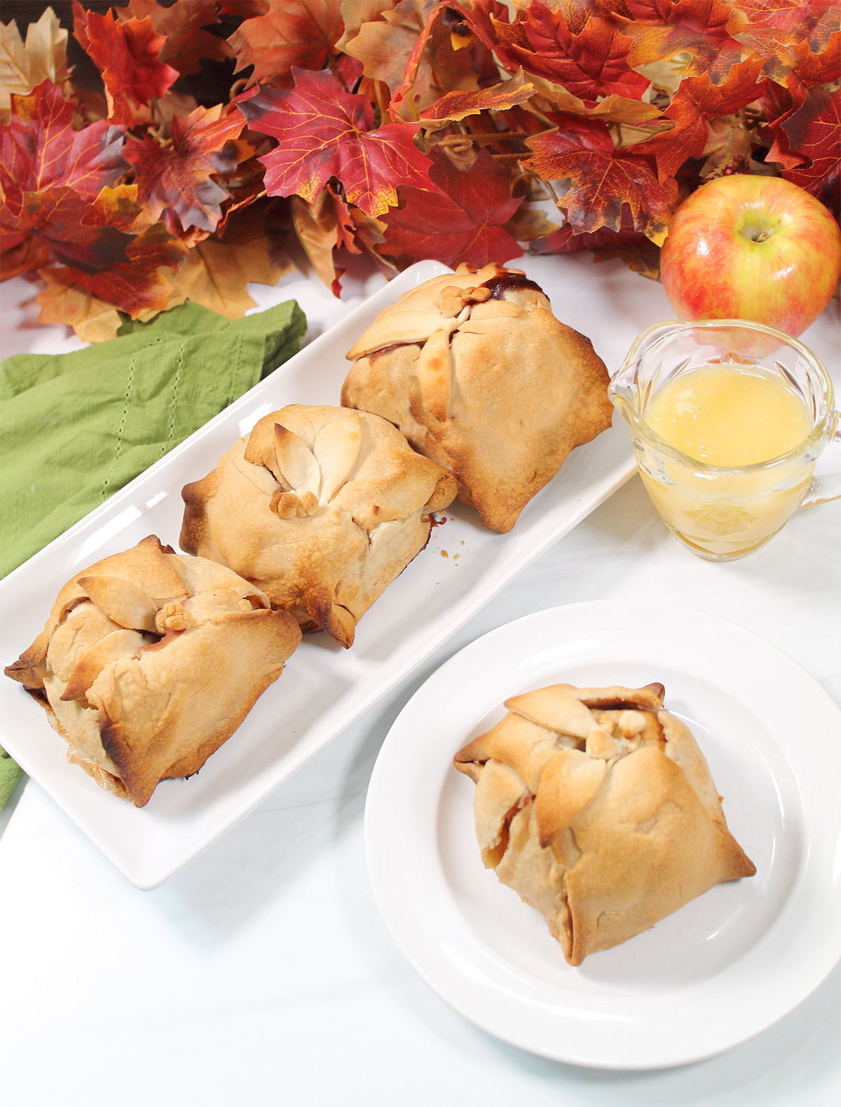 Homemade apple dumplings on platter with one plated.