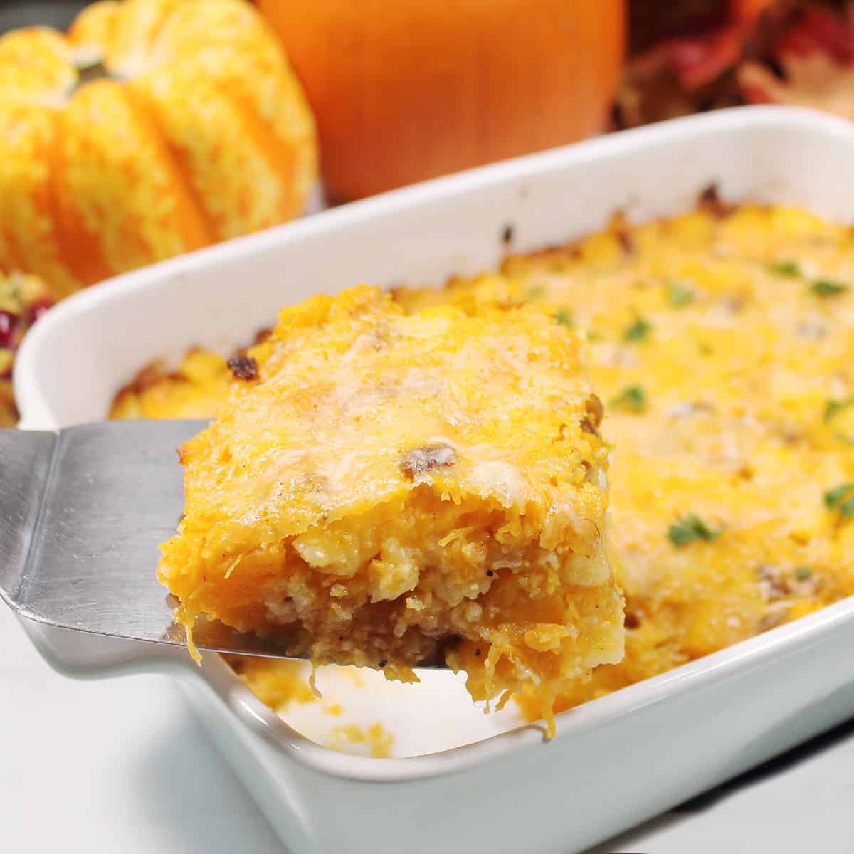 Holding slice of baked polenta over casserole.
