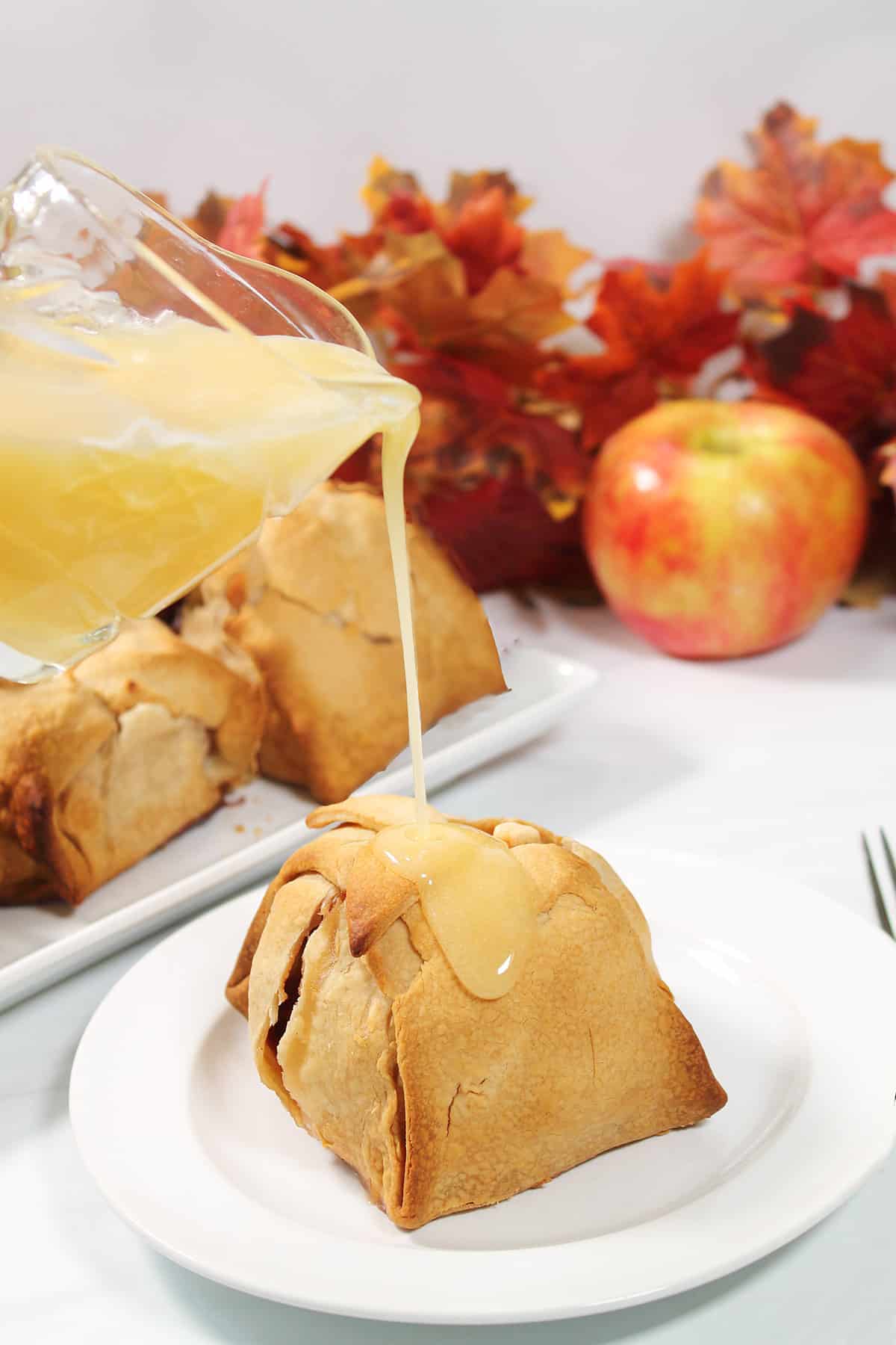 Pouring vanilla sauce over hot apple dumplings.