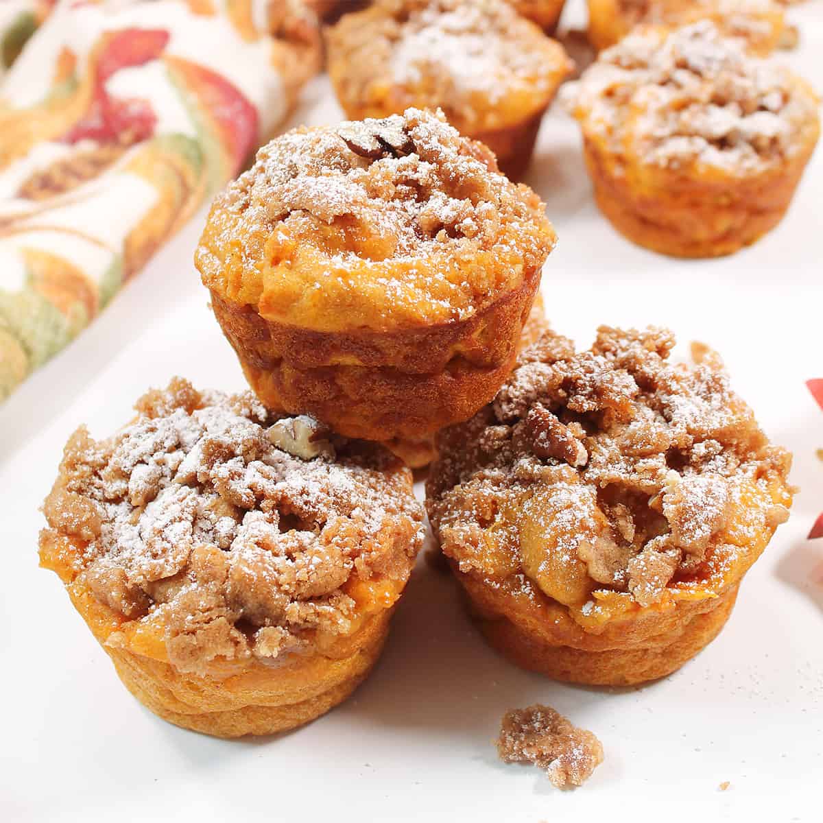 Three stacked muffins on fall table.